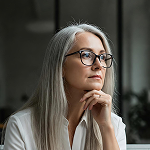 Well-groomed, professional, middle-aged woman, wearing glasses.